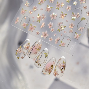 Macro detail of iridescent cherry blossom nail stickers with pearl and gold accents