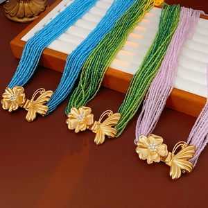 Close-up of multi-layer beaded necklaces with floral butterfly crystal buckles
