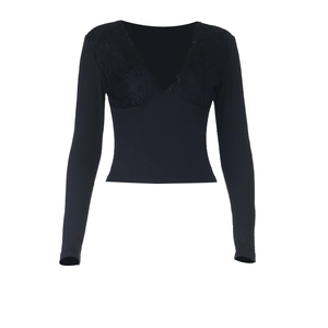 Dettaglio dello scollo a V con pizzo nero su un top a maniche lunghe in maglia a coste