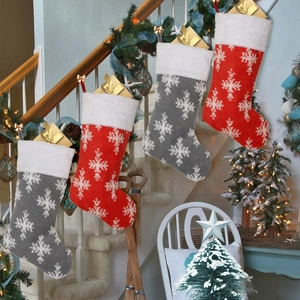 Set of four red and grey Christmas stockings with white snowflake patterns and plush cuffs