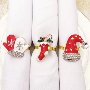Detailed view of Christmas napkin rings featuring enamel holiday glove, sock, and hat designs