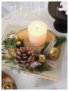 Close-up of Christmas candle with pine cones and golden bells on a wooden base