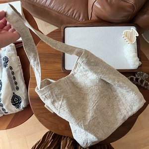 Gros plan d'un sac cabas plissé en coton beige avec une texture gaufrée et bandoulière large