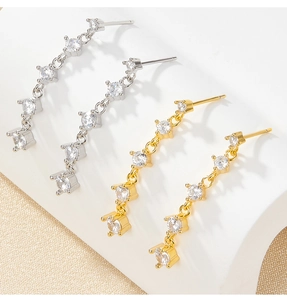 Makro-Detail von S925 Silber-Ohrsteckern mit kaskadierenden Zirkonsteinen in Gold und Silber
