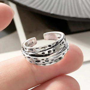 Close-up of S925 engraved stamp on a silver layered open ring with hammered texture