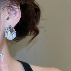 Close-up of a model wearing a large waterdrop-shaped clear zircon stud earring