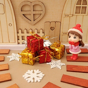 Miniature Christmas scene with red gold gift boxes and girl figure by wooden door