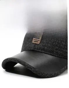 Close-up of winter baseball cap with dark grey wool fabric and black leather brim