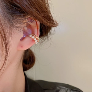 Close-up of a double-layer gold pearl ear cuff worn on the ear bone, no piercing needed