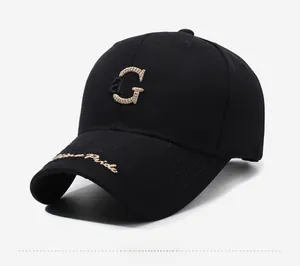 Détail de casquette noire avec broderie 3D aG et texte doré cursif sur la visière