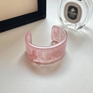 Detailaufnahme der rosa Marmortextur auf einem unregelmäßigen breiten Acrylharz Armreif