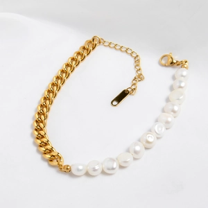 Vue détaillée du bracelet en chaîne dorée et perles d'eau douce sur tissu de soie blanc