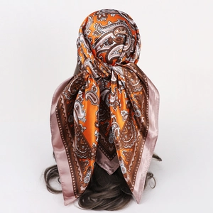 Orange paisley silk scarf for women styled as a fashionable bohemian headscarf