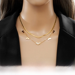Detail of layered gold titanium necklace featuring a snake chain and heart pendants