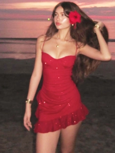 Slim fit red sequin camisole dress with ruffle hem shown on a sunset beach