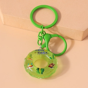 Close-up of green lifebuoy keychain with matching ring on a beige geometric stand