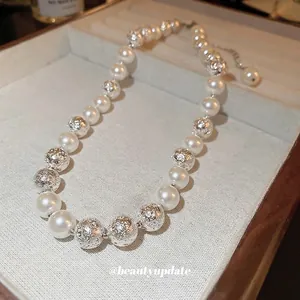Elegant pearl necklace with textured silver lava beads on a beige jewelry tray display