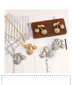 Dettaglio del set di gioielli a ciliegia con strass brillanti e placcatura oro PVD