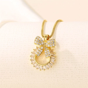 Gold stainless steel bowknot pendant necklace with sparkling rhinestones on beige fabric