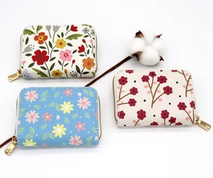 Detailed view of floral pattern credit card holders with golden heart-shaped zippers