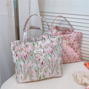 Detail view of pink heart jacquard and floral canvas tote bags with simple wish label