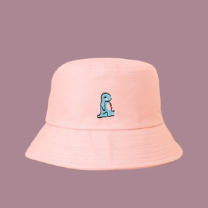 Close-up of blue dinosaur embroidery on a soft pink wide-brimmed cotton fisherman hat