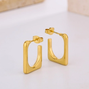 Polished 18K gold plated oval eggshell earrings on a minimalist stone display