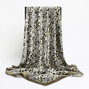 Elegant leopard print satin silk scarf with khaki borders displayed on a black stand