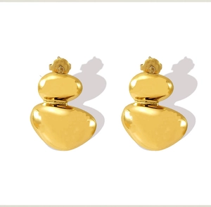 Detailed view of golden irregular pebble earrings with a polished liquid metal texture