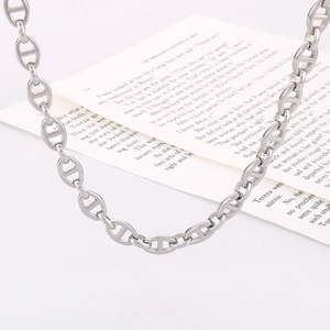 Polished silver stainless steel pig nose chain necklace on a minimalist book background