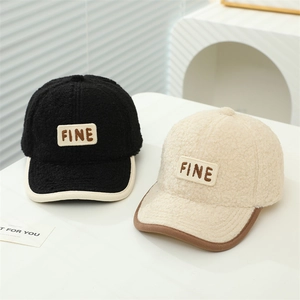 Détail de la texture polaire épaisse des casquettes avec broderie de lettres FINE