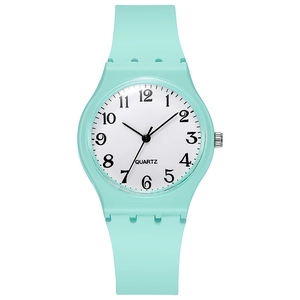 Macro detail of mint green silicone watch strap and minimal white dial with quartz movement