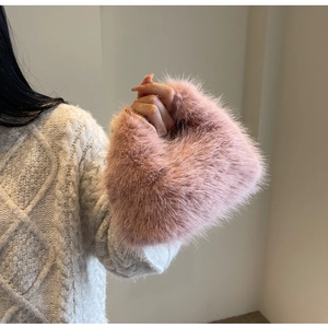 Close-up of soft pink faux fur material on the bag with a cozy winter sweater