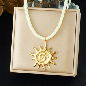 Gros plan du pendentif soleil doré avec motif en spirale sur support d'affichage