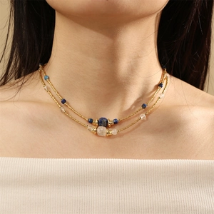 Detail of layered gold beaded necklaces featuring blue lapis and translucent stones