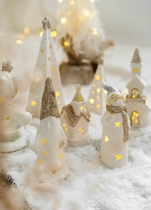 Detail of glowing ceramic Christmas decor with warm LED lights and gold glitter accents