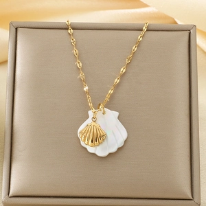Detail of golden shell and white shell pendants on necklace in jewelry box