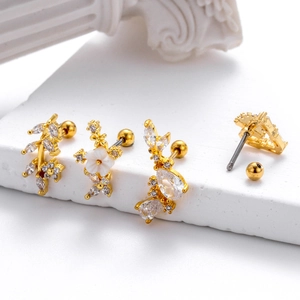 Set of four gold heart and floral stud earrings with clear zircon on a stone pedestal
