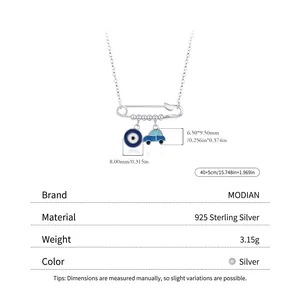 Sterling silver paperclip necklace with evil eye and car charms on a white background