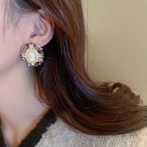 Detailed view of vintage cameo earrings featuring purple crystals and gold portrait relief