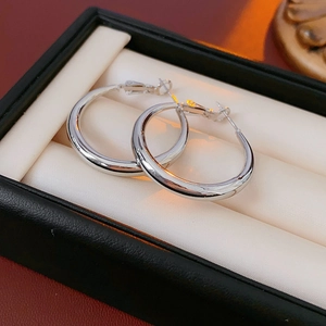 Close-up of polished silver hoop earrings displayed in a premium leather jewelry box