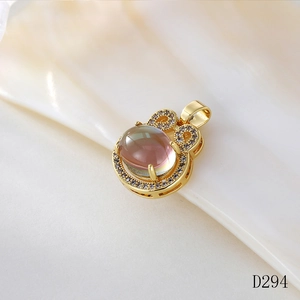 Detailed view of a gold moonstone pendant with a bow design on a pearl shell background