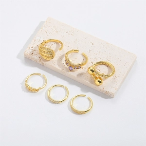 Detail of 6-piece adjustable gold ring set with purple gemstone and polished beads