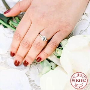 Detailed close-up of a 925 sterling silver solitaire diamond ring worn on a model's finger