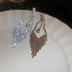 Detailed close-up of luxury silver tassel earrings with sparkling zircon crystals in a tray