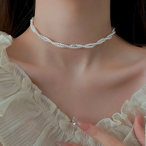 Dettaglio macro della collana di perle a due strati con pendente di diamante su modella