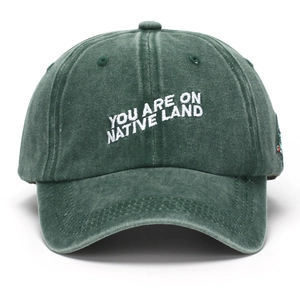 Washed green cotton baseball cap with You Are On Native Land embroidery and side patch