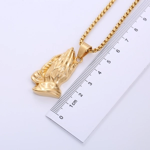 18k gold plated praying hands pendant necklace shown with a centimeter ruler for size scaling