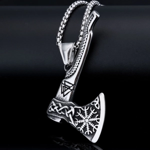 Macro shot of silver Viking battle axe pendant with Celtic knot and Vegvisir compass detail