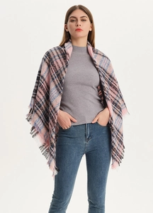Detail of pink and blue plaid scarf with fringe tassels shown on a model